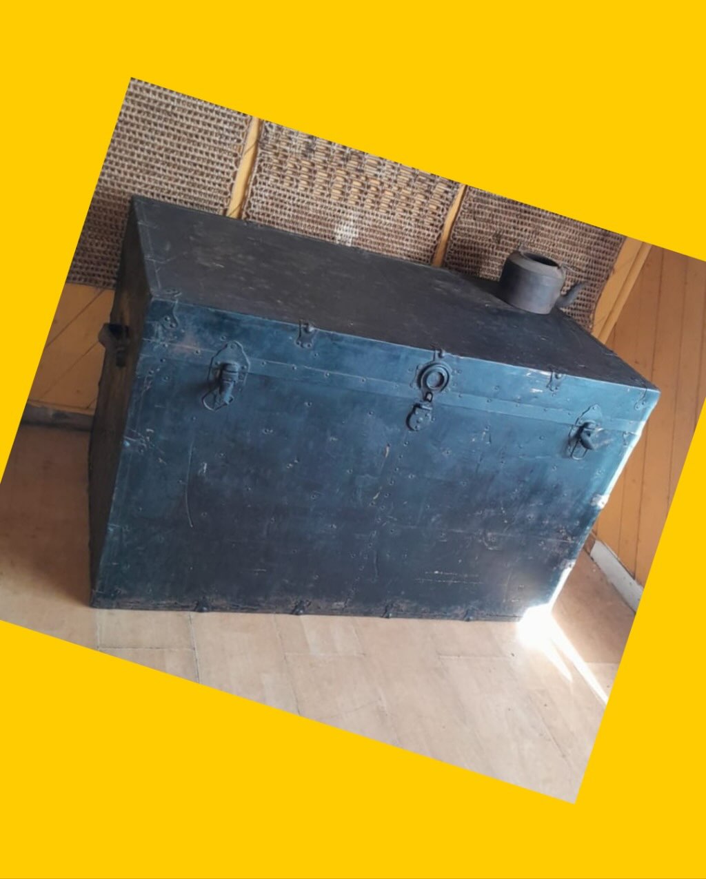 Baúl metálico de viajes con detalles de bronce y asas de cuero